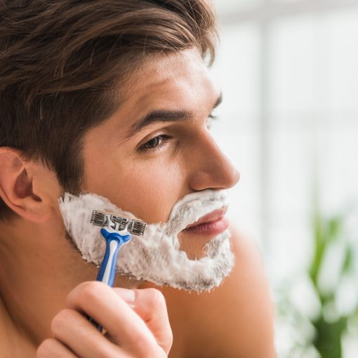 Seriöser Mann rasiert seinen Bart